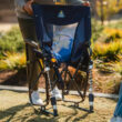 Adjustable Rocker in navy being unfolded, showing its breathable mesh back panel and spring-loaded legs.